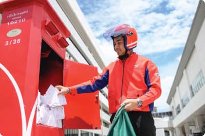Delivery person by a postbox